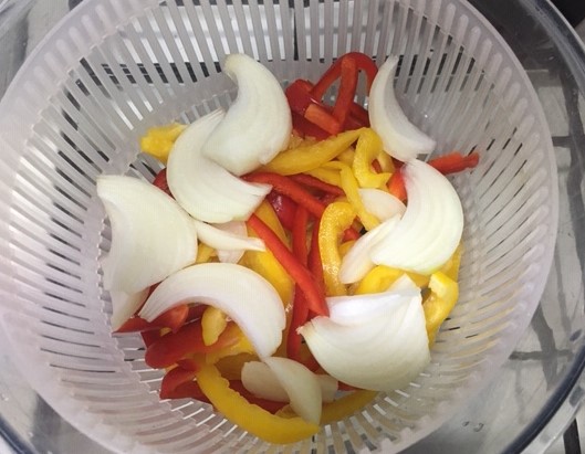 Image of cut red and yellow peppers and onions.