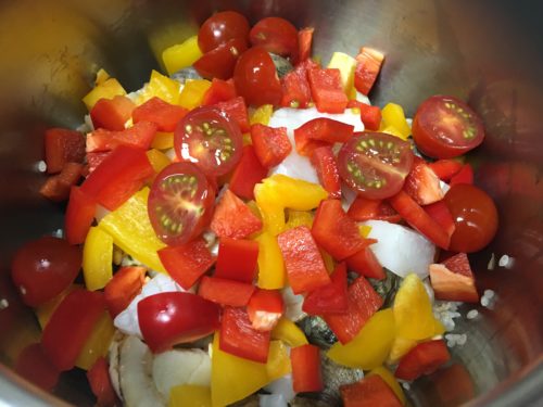 Image: Putting the red and yellow peppers and tomatoes into the pot.