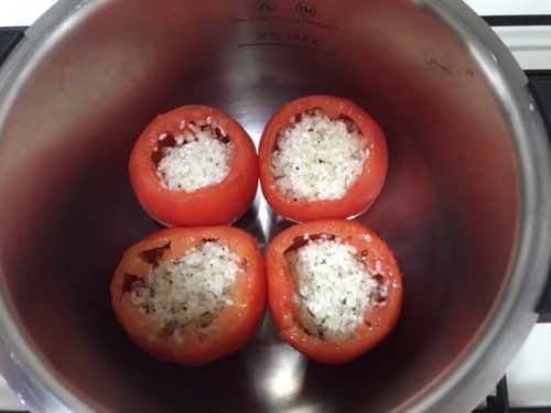トマトにライスを詰めて鍋に入れる
